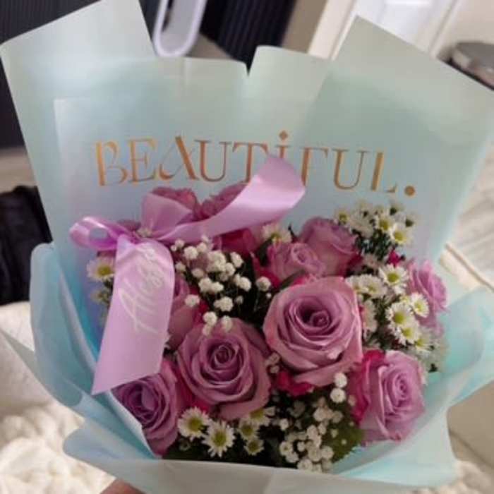 Bouquet of pink and lavender roses with small white filler flowers