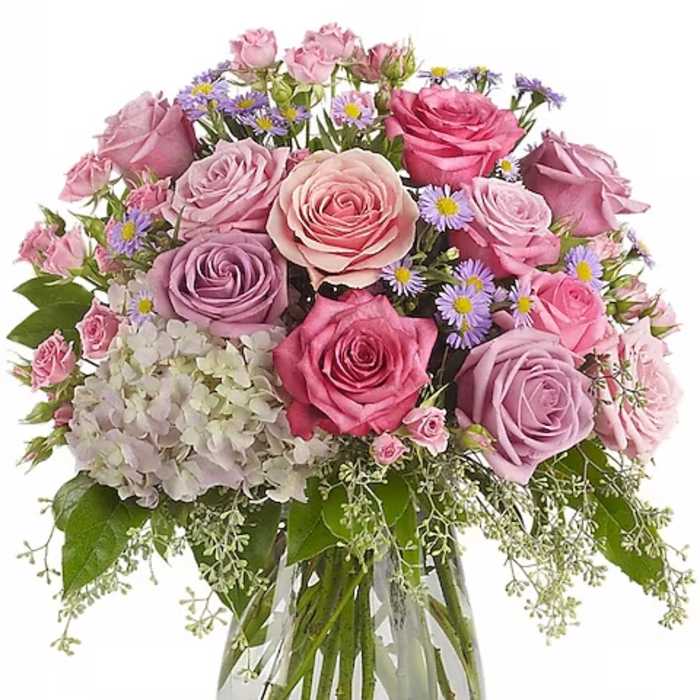 Bouquet of pink and lavender roses in a clear glass vase