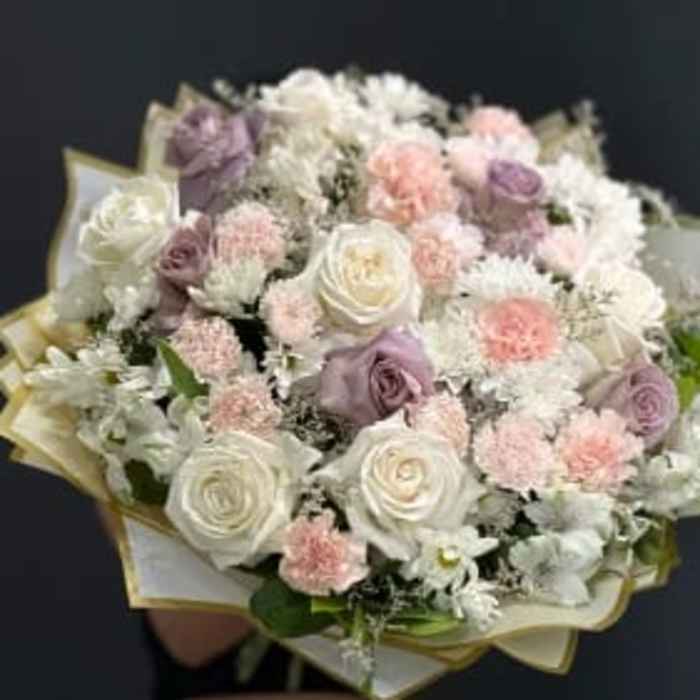 Bouquet of white, blush, and lavender roses with small white flowers