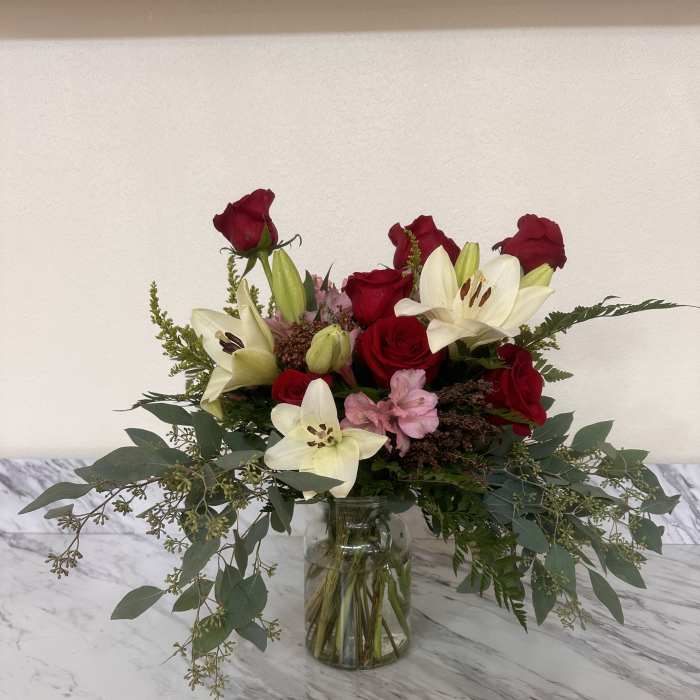 Bouquet of red roses and white lilies in a glass vase