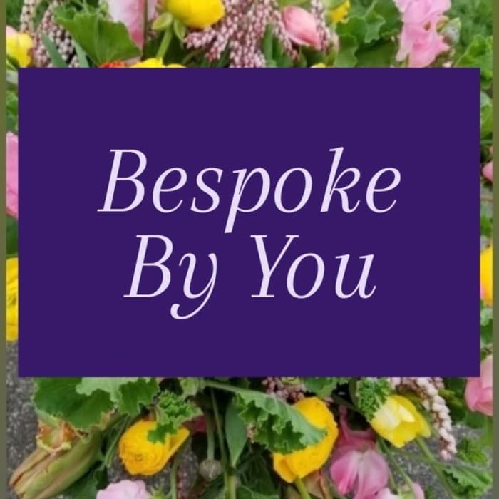 Colorful mixed flowers blurred behind a purple panel with the words Bespoke By You.