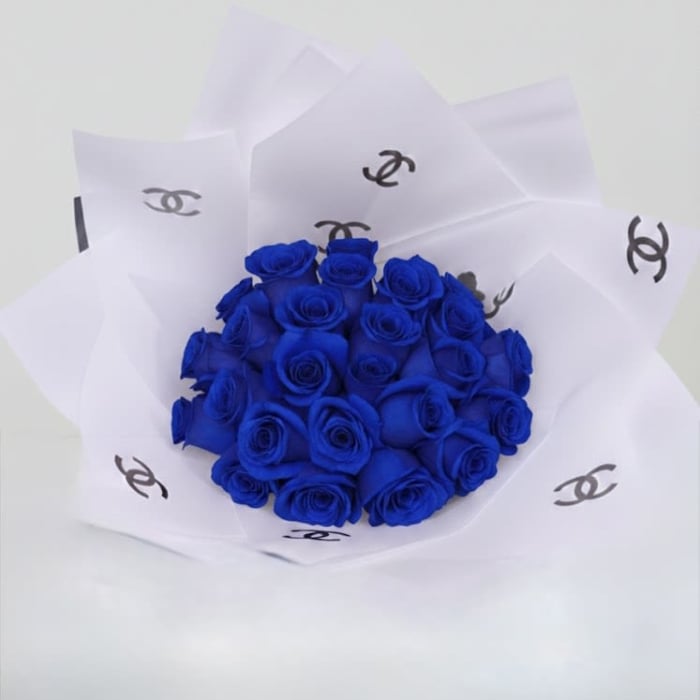 Bouquet of vivid blue roses wrapped in white paper