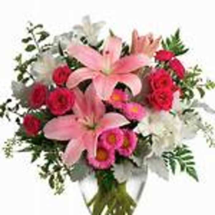 Pink lilies and red roses in a clear glass vase