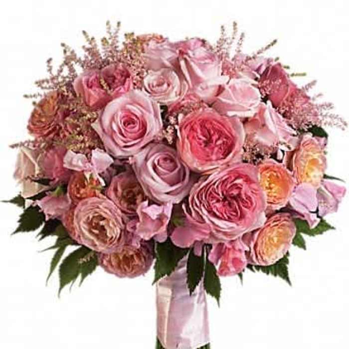 Round hand-tied bouquet of pink and peach roses with a pink ribbon wrap