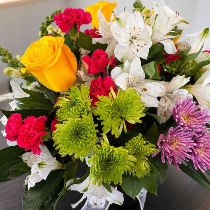 Mixed bouquet with yellow roses, white lilies, pink carnations, and green chrysanthemums