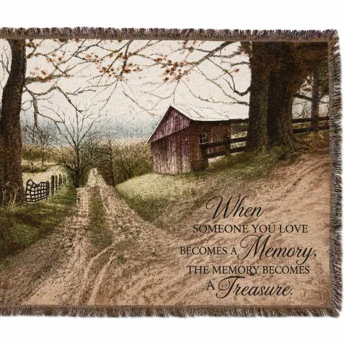Fringed throw blanket with a rustic barn scene and memorial quote