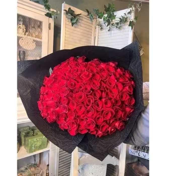Large bouquet of red roses wrapped in black paper