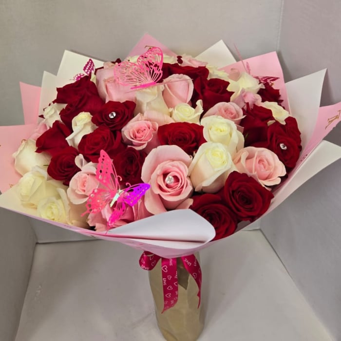 Bouquet of red, pink, and white roses with butterfly picks