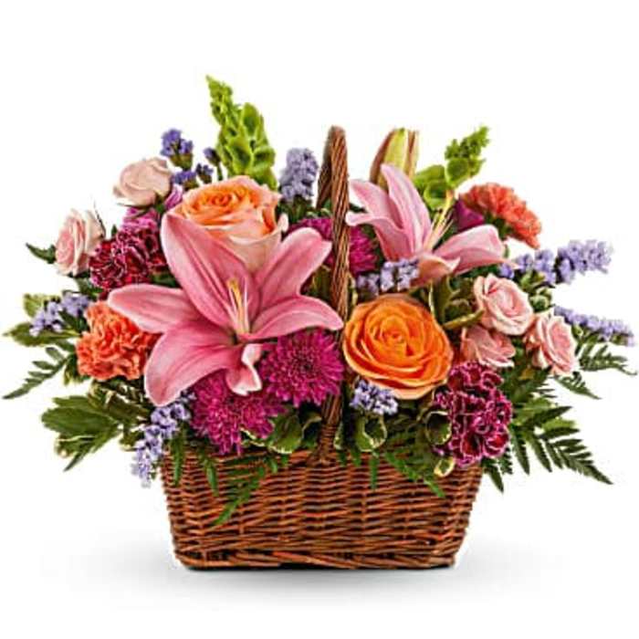 Basket arrangement with pink lilies, orange roses, and purple flowers