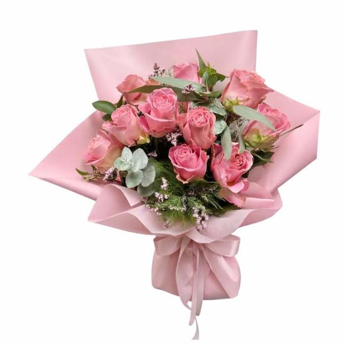 Pink rose bouquet wrapped in pink paper with a ribbon