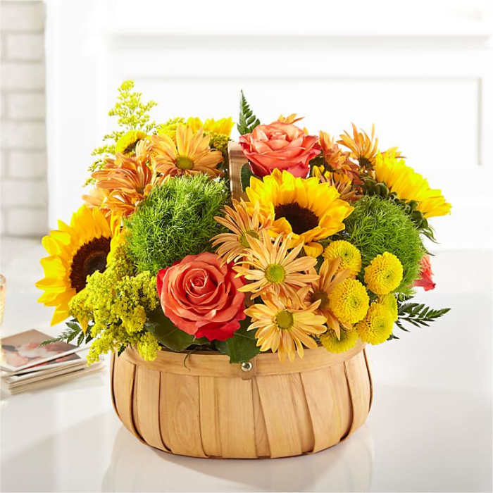 Basket arrangement with sunflowers, roses, and yellow daisies