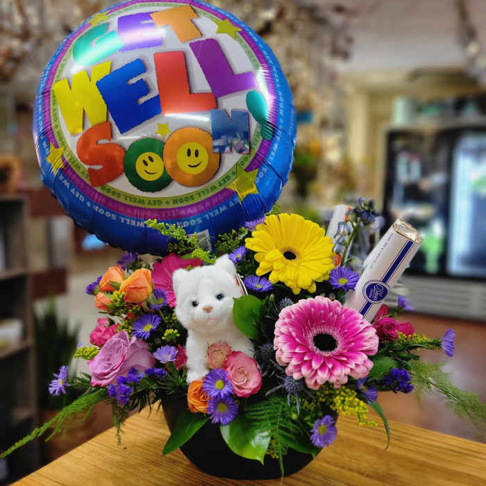 Flower arrangement with a "Get Well Soon" balloon and a small white teddy bear
