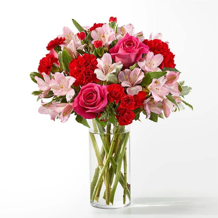 Pink roses and red carnations in a clear glass vase