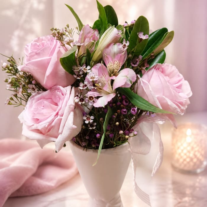 Pink rose and alstroemeria bouquet in a white vase