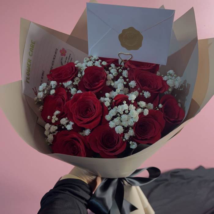 Bouquet of red roses with white baby's breath in beige and blue wrap