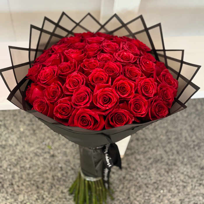 Bouquet of red roses wrapped in black paper