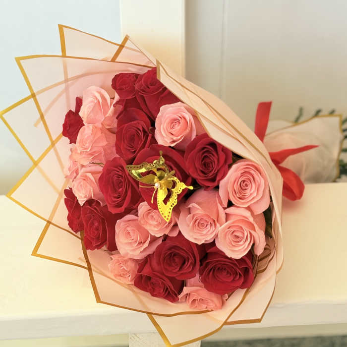 Bouquet of red and pink roses wrapped in translucent paper