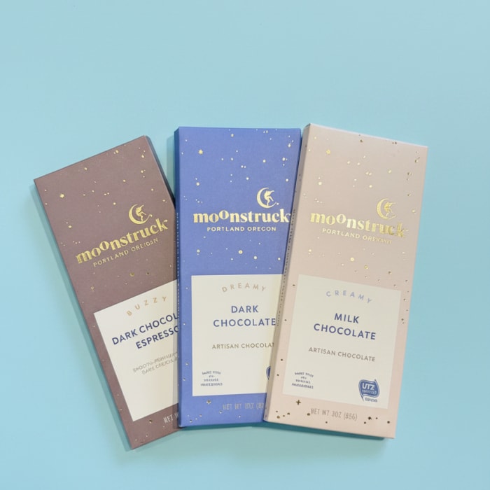 Three chocolate bars in pastel wrappers on a blue background