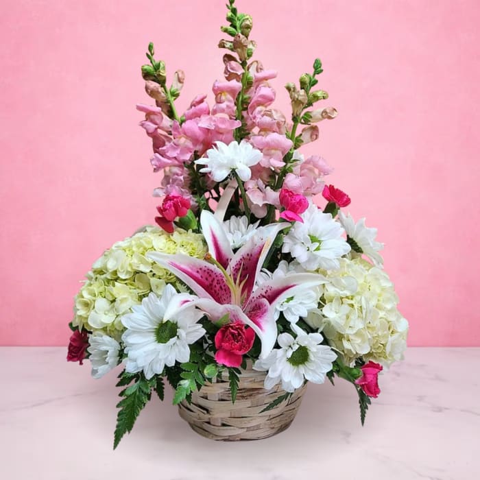 Basket arrangement with pink lilies, white daisies, and pale hydrangeas