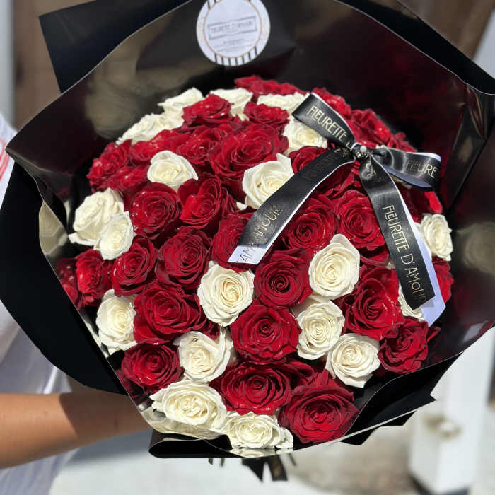 Bouquet of red and white roses wrapped in black paper