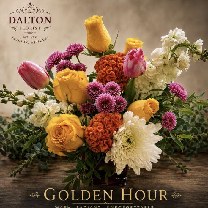 Bouquet of yellow roses, pink tulips, and white blooms in a vase