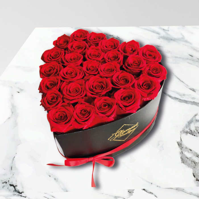 Heart-shaped box of red roses tied with a red ribbon