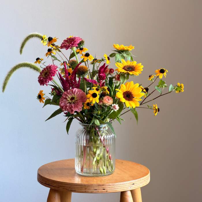 Mixed bouquet of yellow and pink flowers in a clear glass vase