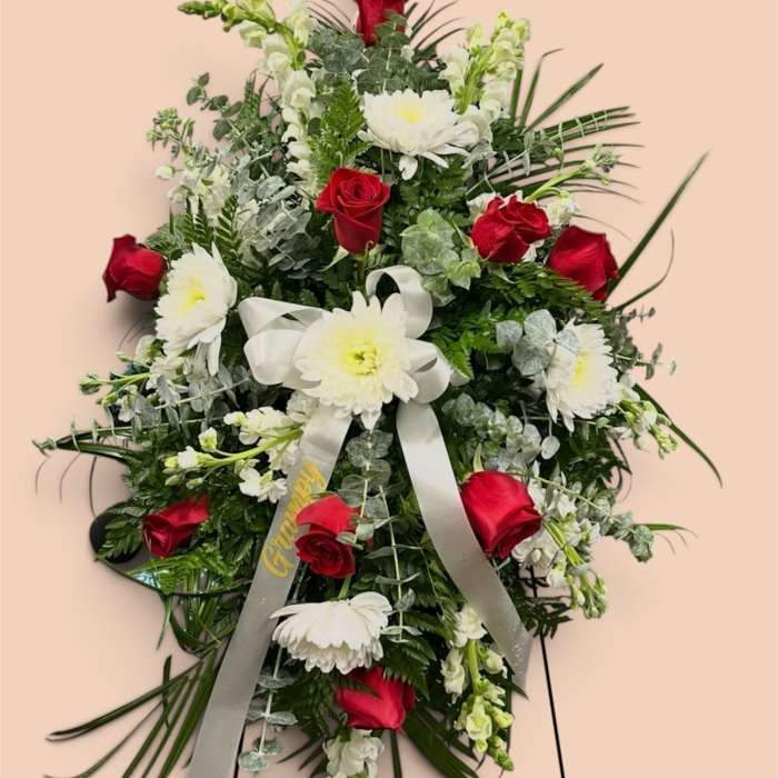 Standing floral spray with red roses and white daisies on a ribboned easel