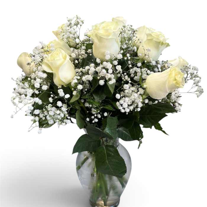 White roses and baby's breath in a clear glass vase