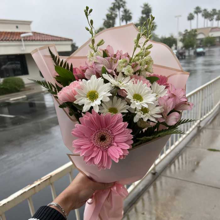 Pink bouquet with gerbera daisies and white daisy flowers wrapped in pink paper