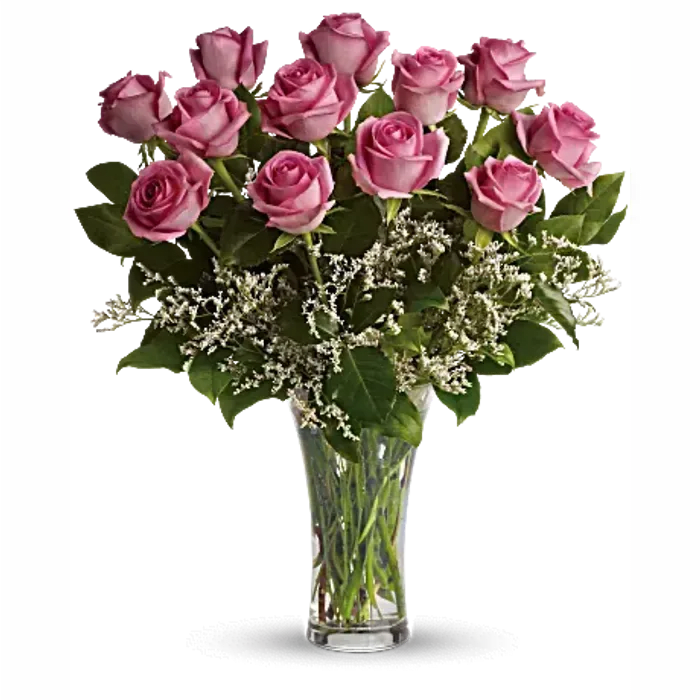 Pink roses arranged in a clear glass vase with white filler flowers