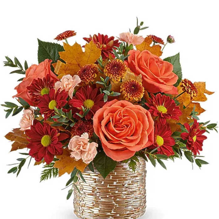 Orange roses and red chrysanthemums in a woven basket vase