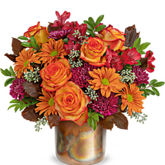 Orange roses and daisies in a bronze vase