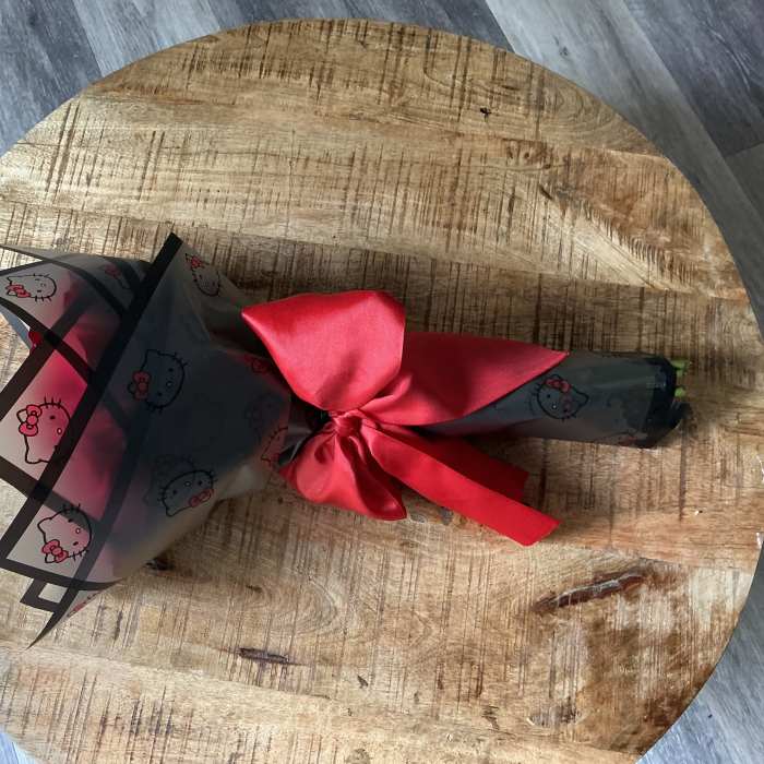 Wrapped bouquet tied with a red satin ribbon