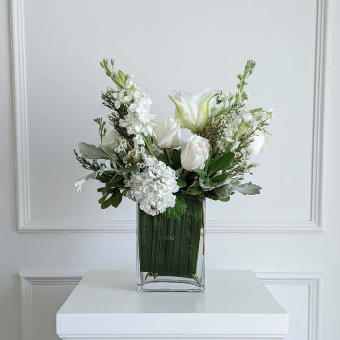 White floral arrangement in a clear rectangular vase