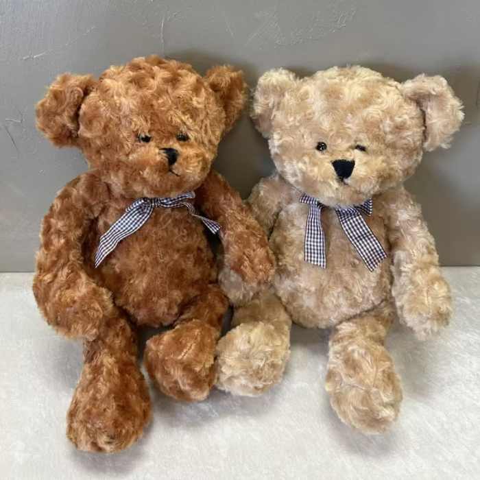 Two plush teddy bears with gingham bows sit side by side.