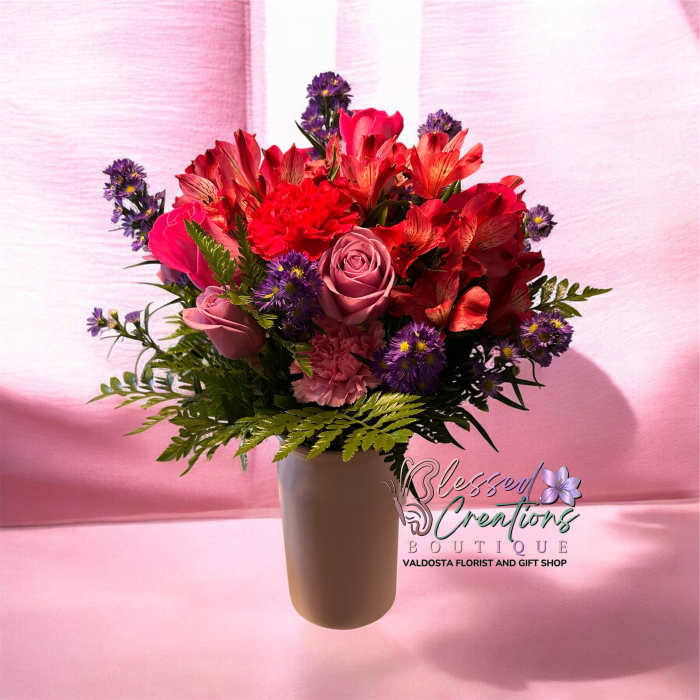 Pink and red mixed bouquet in a white vase