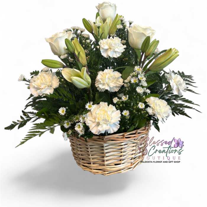 White roses and lilies arranged in a wicker basket