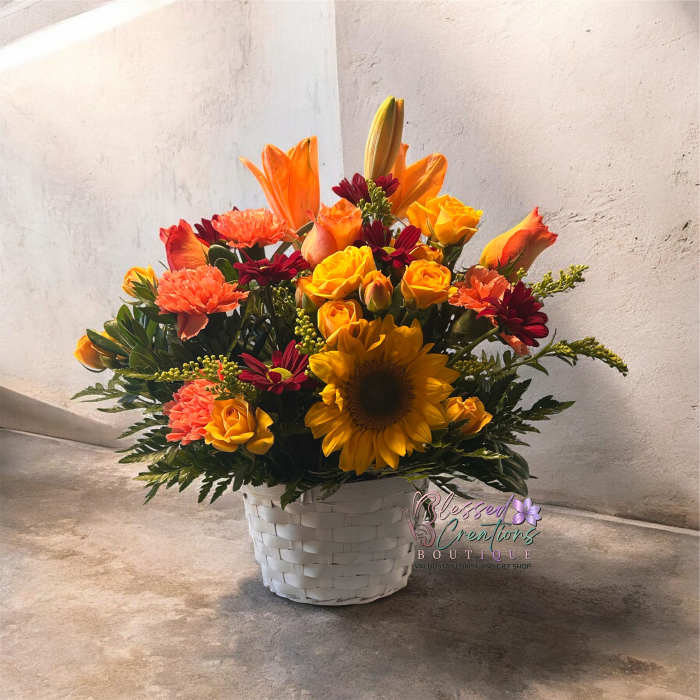 Bright mixed flower arrangement in a white basket