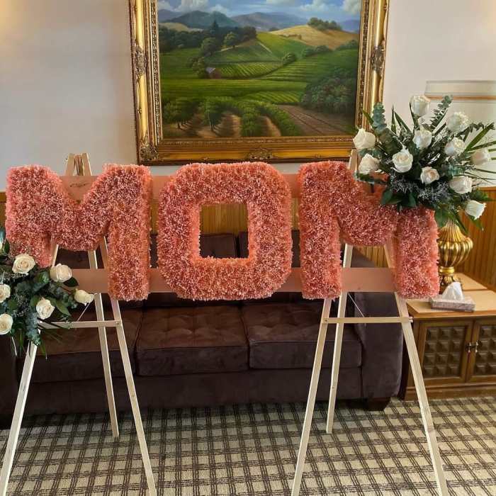 Pink floral letters on easels with white rose arrangements on both sides
