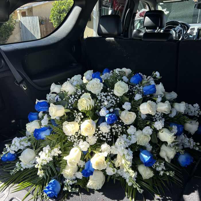 Large bouquet of white and blue roses arranged in a car cargo area
