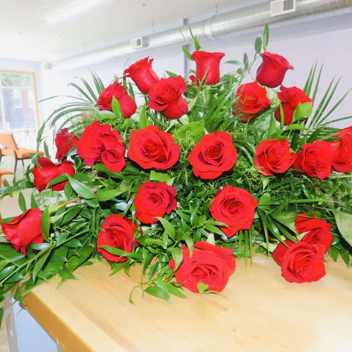 Large arrangement of red roses with greenery on a table