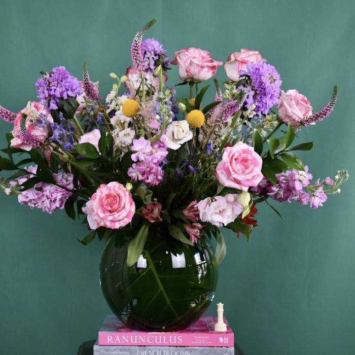Pink and purple mixed bouquet in a dark glass vase