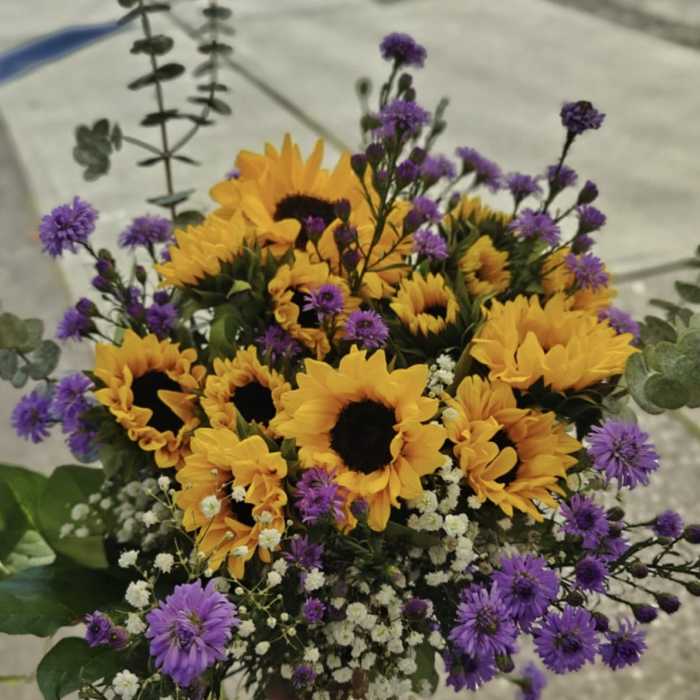 Bouquet of yellow sunflowers and purple filler flowers