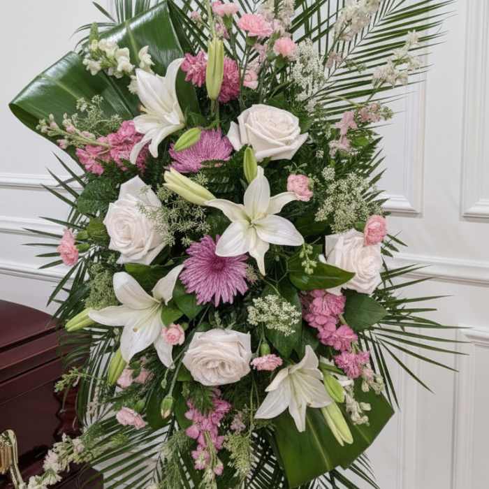 Standing floral spray with white lilies, roses, and pink blooms