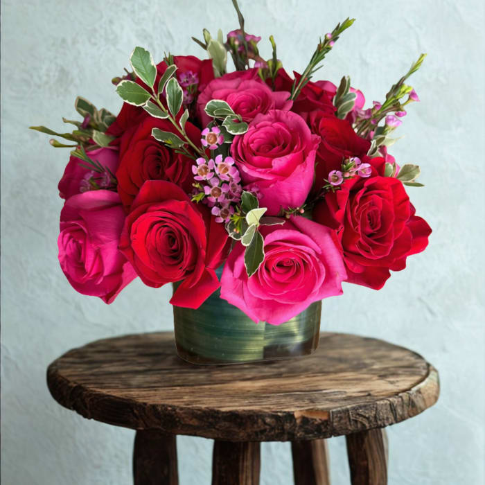 Mixed bouquet of white, pink, orange, and magenta flowers in a green vase