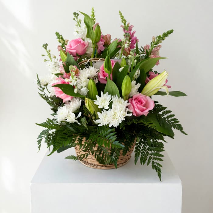 Pink roses and white lilies in a wicker basket