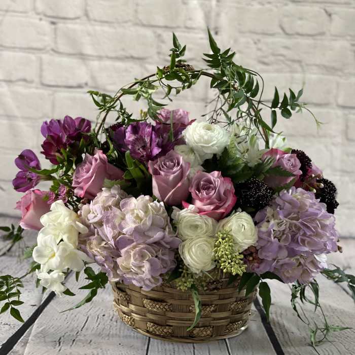 Basket arrangement of pink, white, and purple flowers