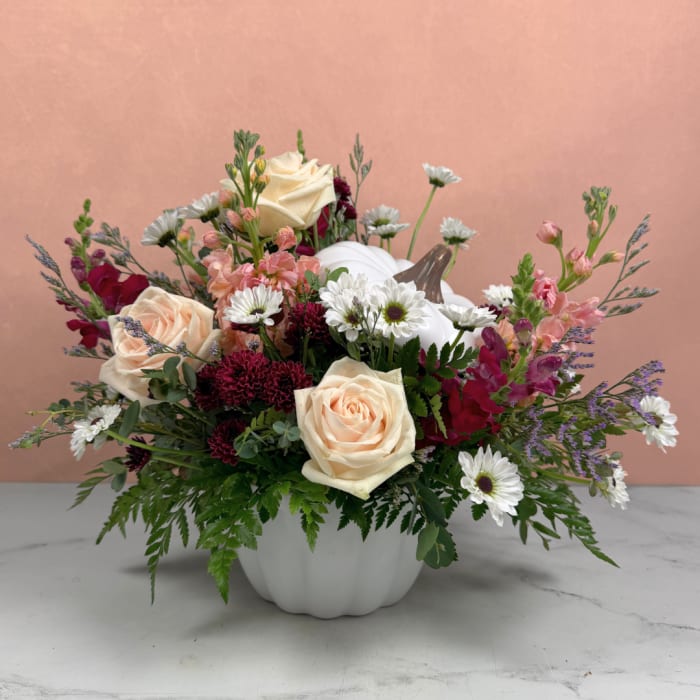 Mixed bouquet in a white pumpkin vase with cream roses and white daisies
