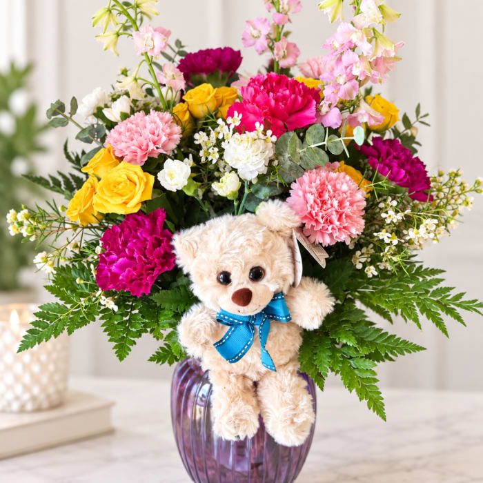 Colorful bouquet with a teddy bear in a purple vase